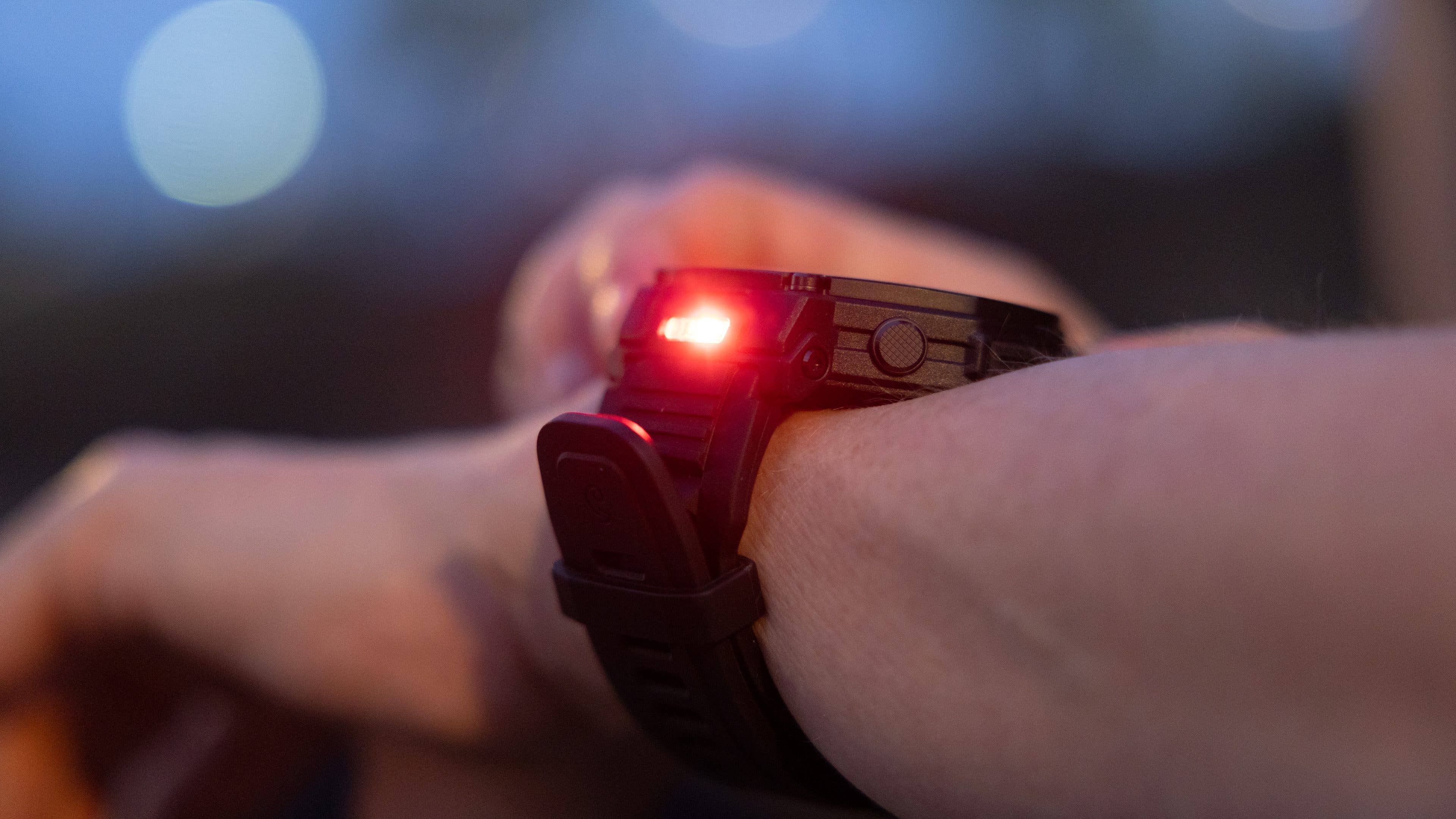 Gros plan sur une montre intelligente Amazfit T-Rex Pro 3 affichant une lumière rouge au poignet.