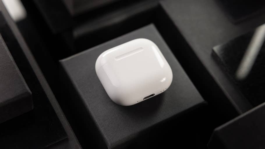 Une paire du0027AirPods blancs Apple reposant sur une surface noire.