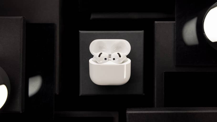 AirPods blancs du0027Apple dans leur étui de chargement sur un fond sombre.