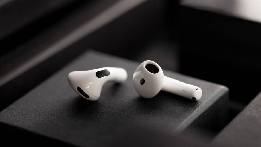 AirPods blancs Apple sur un fond sombre, mettant en valeur leur design élégant.