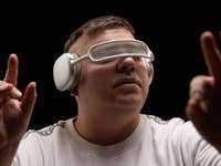 Un homme portant un casque Bluetooth Apple AirPods Max sur ses yeux comme s'il s'agissait d'un casque de réalité virtuelle.