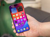 L'iPhone 15 Pro Max d'Apple vu de face, tenu dans une main droite avec son écran allumé