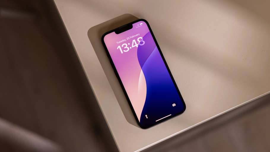 Un Apple iPhone 16e posé sur une table, affichant lu0027heure 13:48 et la date 26 février.