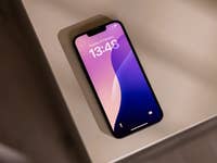 Un Apple iPhone 16e posé sur une table, affichant l'heure 13:48 et la date 26 février.