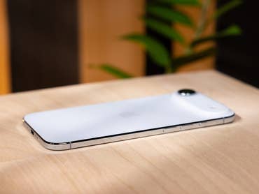 Un iPhone Air blanc d'Apple est posé sur une surface en bois.