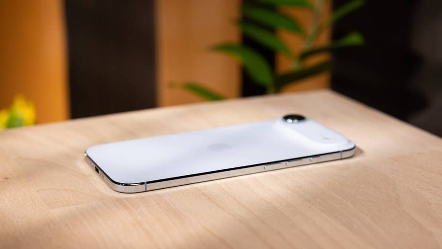 Un iPhone Air blanc d'Apple posé sur une surface en bois.