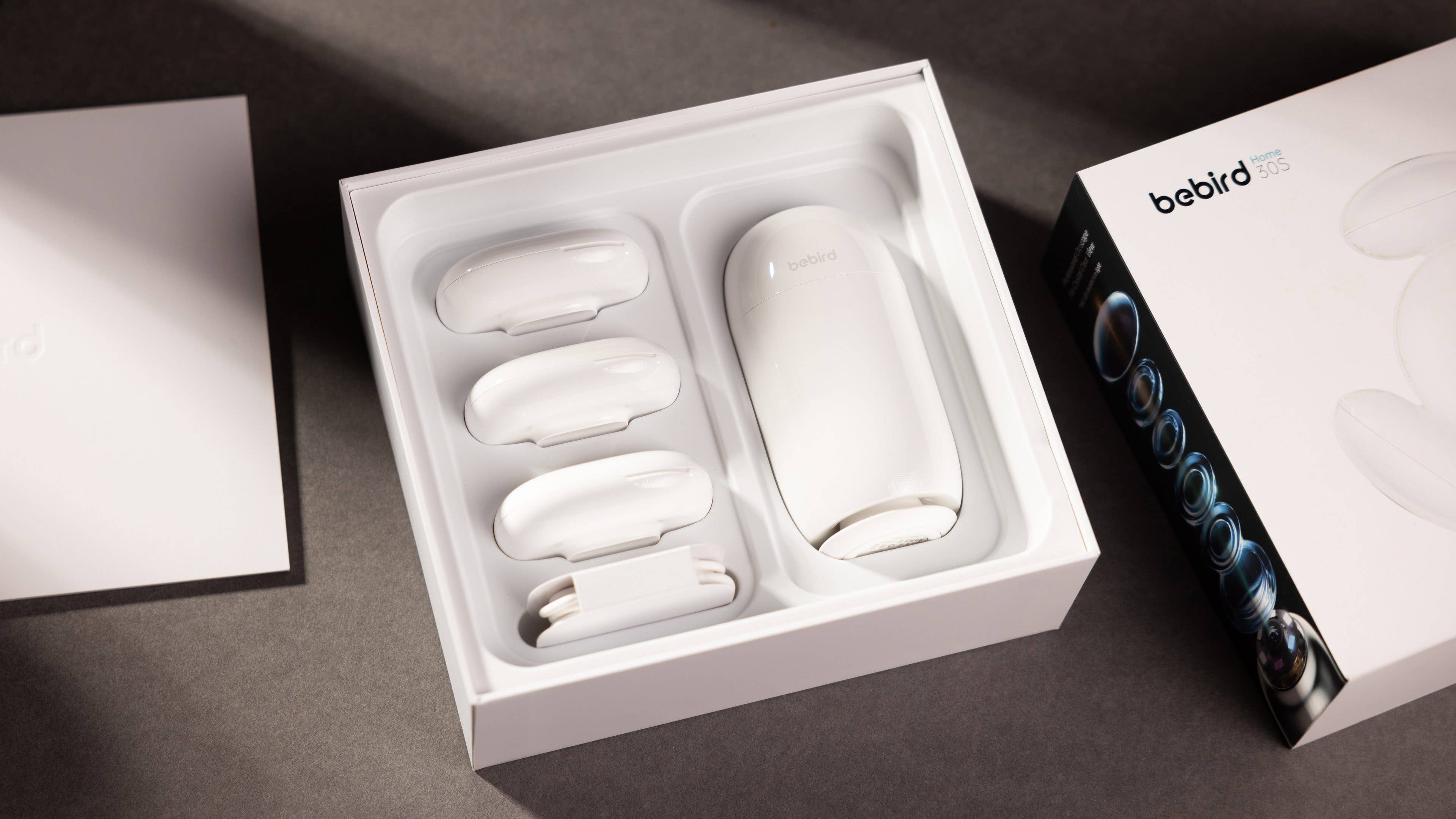 Un appareil bebird-home-30s blanc avec trois accessoires dans une boîte, à côté d