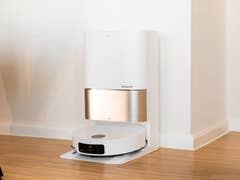 Un aspirador robot Dreame X50 Ultra acoplado a su estación de carga en un interior moderno.