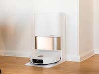 Un aspirador robot Dreame X50 Ultra acoplado a su estación de carga en un interior moderno.