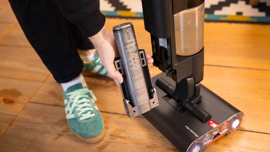 Une personne retire un réservoir du0027un aspirateur Dyson wash.