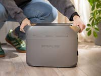 Une personne accroupie tenant la station d'alimentation portable EcoFlow Delta 3 Plus à l'intérieur.