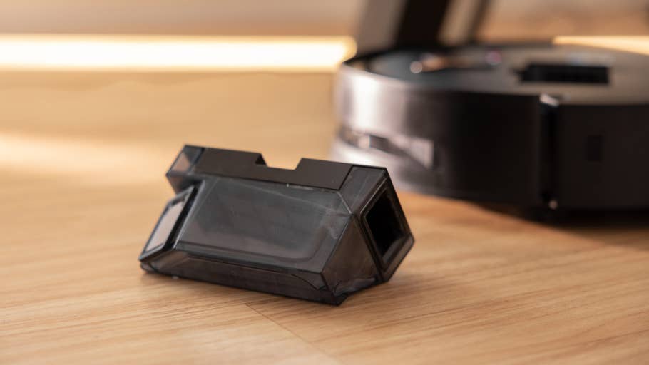 Un composant noir Ecovacs Deebot X8 Pro Omni sur un sol en bois.