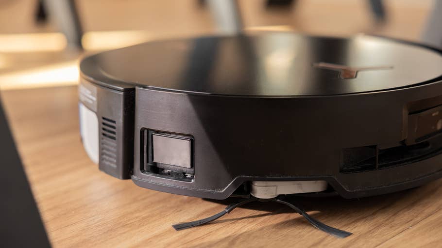 Gros plan sur lu0027aspirateur robot Ecovacs Deebot X8 Pro Omni sur un sol en bois.