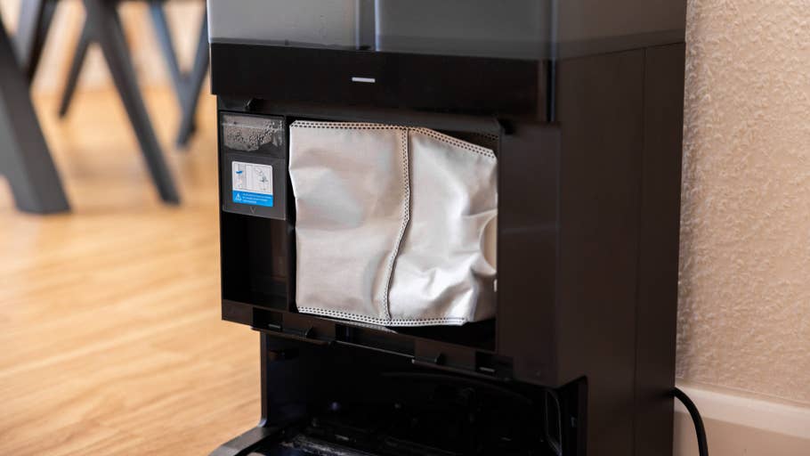 Gros plan du compartiment à poussière de lu0027Ecovacs Deebot X8 Pro Omni avec un sac filtrant à lu0027intérieur.