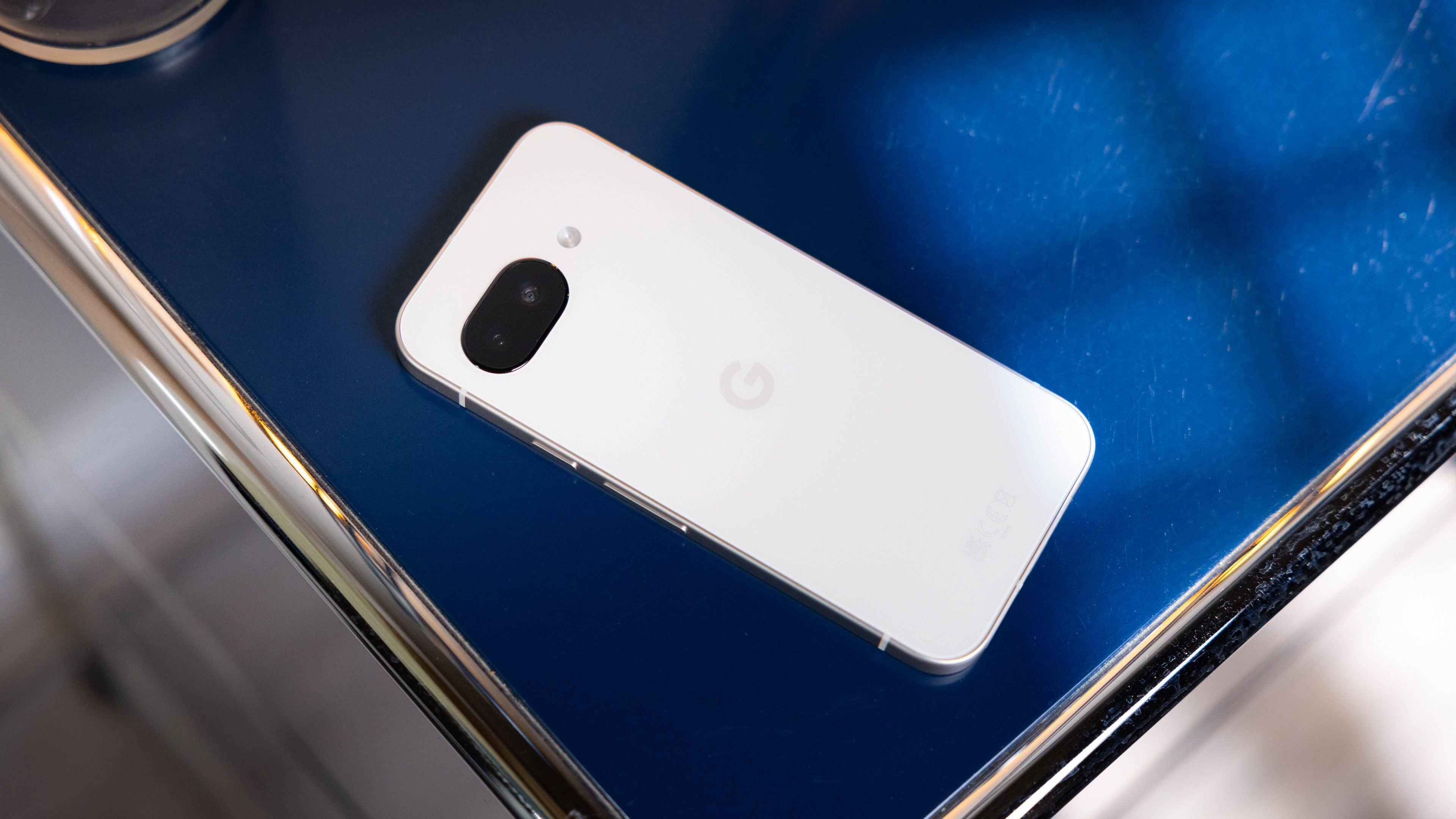 Un smartphone Google Pixel 9a posé sur une surface bleue.