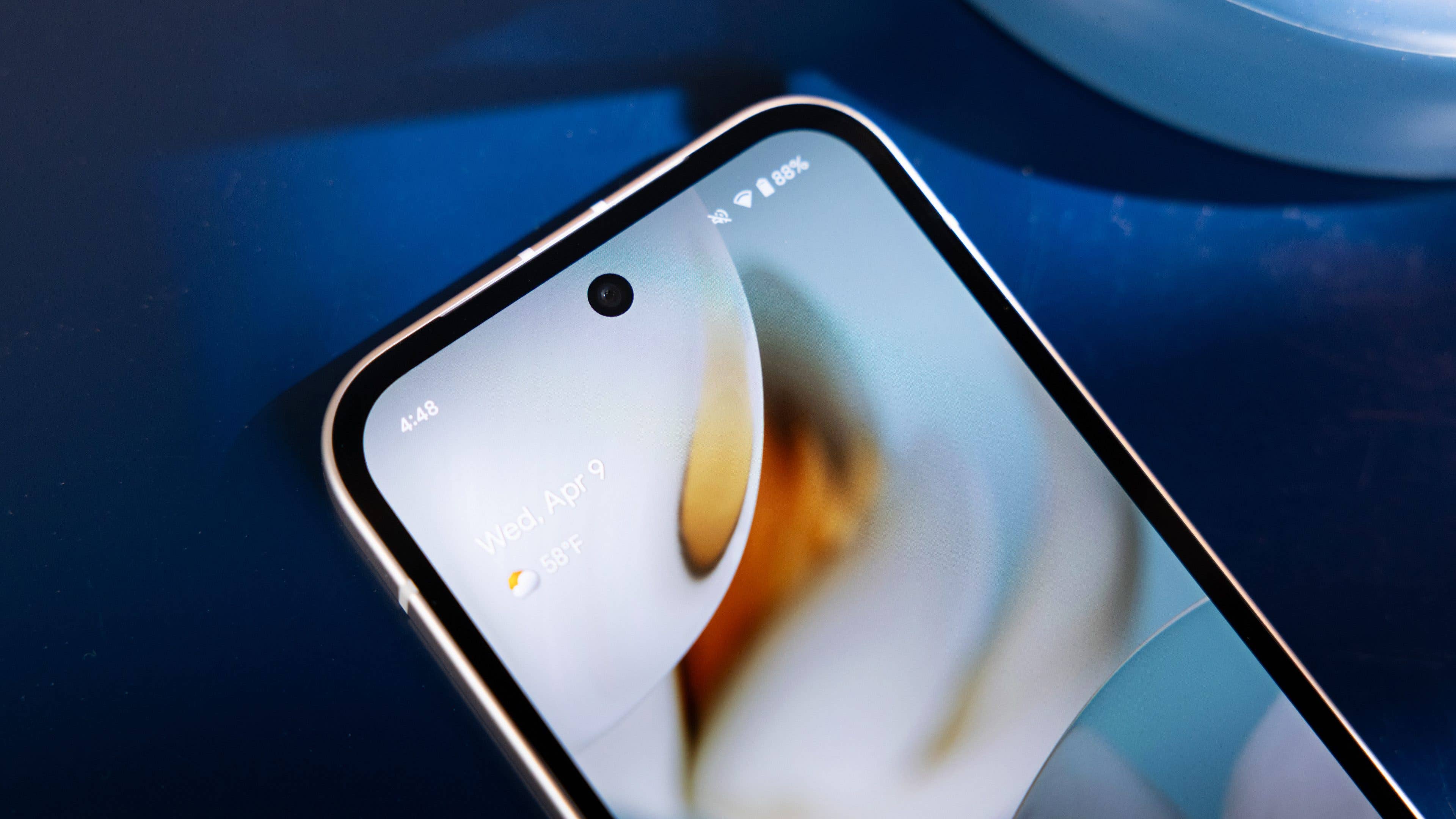 Gros plan d'un smartphone Google Pixel 9a affichant l'écran d'accueil avec la date et la météo.
