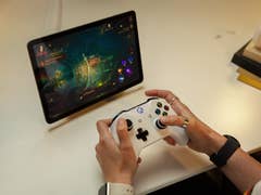 Une personne joue à un jeu sur la tablette Google Pixel à l'aide d'une manette Xbox connectée.