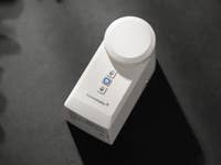 Une serrure intelligente Homematic IP blanche avec un dessus circulaire et deux boutons sur le côté.