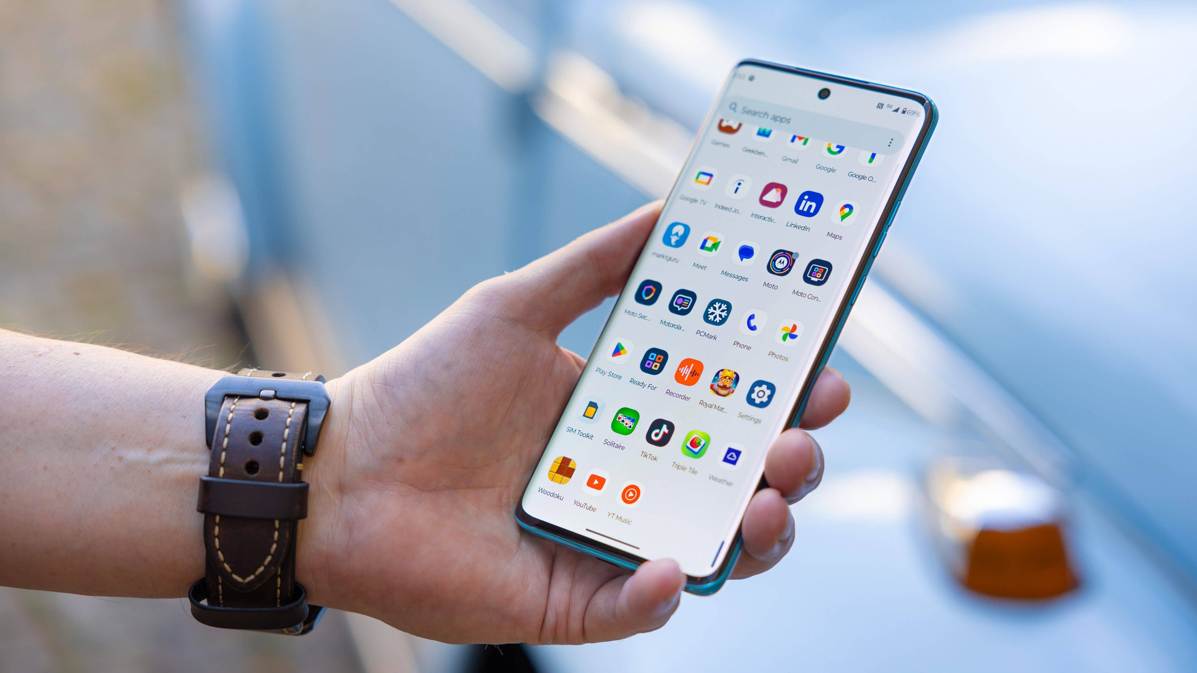 Le Motorola Edge 40 Neo tenu dans une main gauche vu de face avec l Le Motorola Edge 40 Neo tenu dans une main gauche vu de face avec l