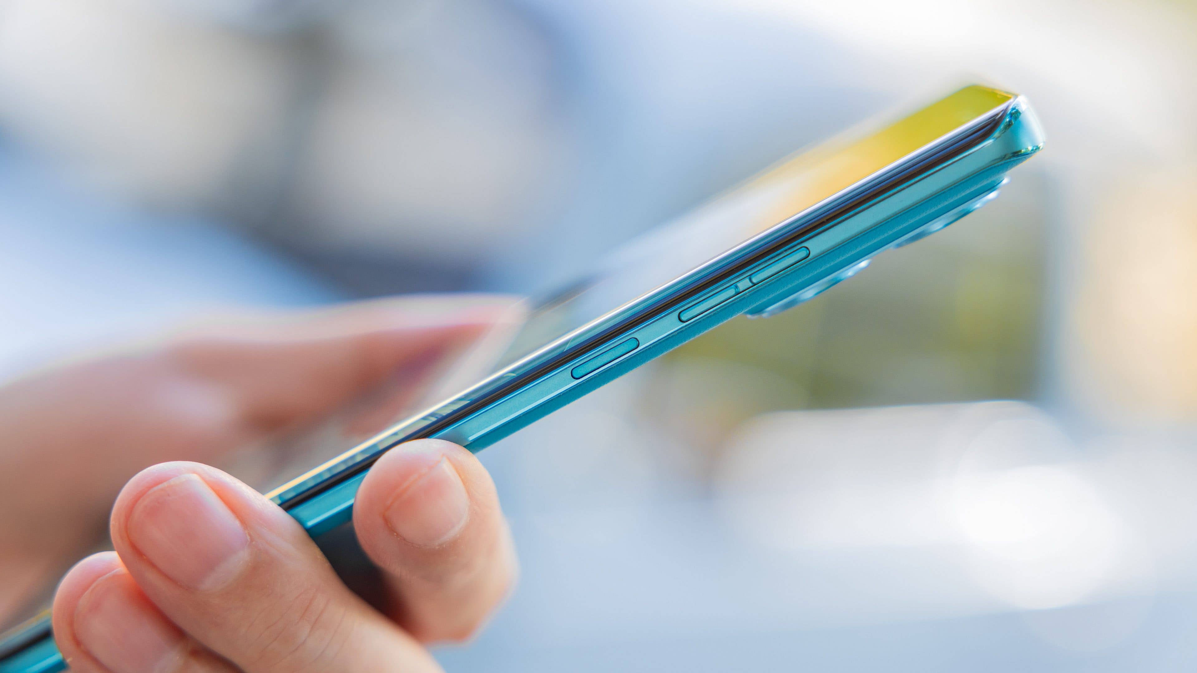 Le Motorola Edge 40 Neo vu du côté droit tenu dans une main Le Motorola Edge 40 Neo vu du côté droit tenu dans une main