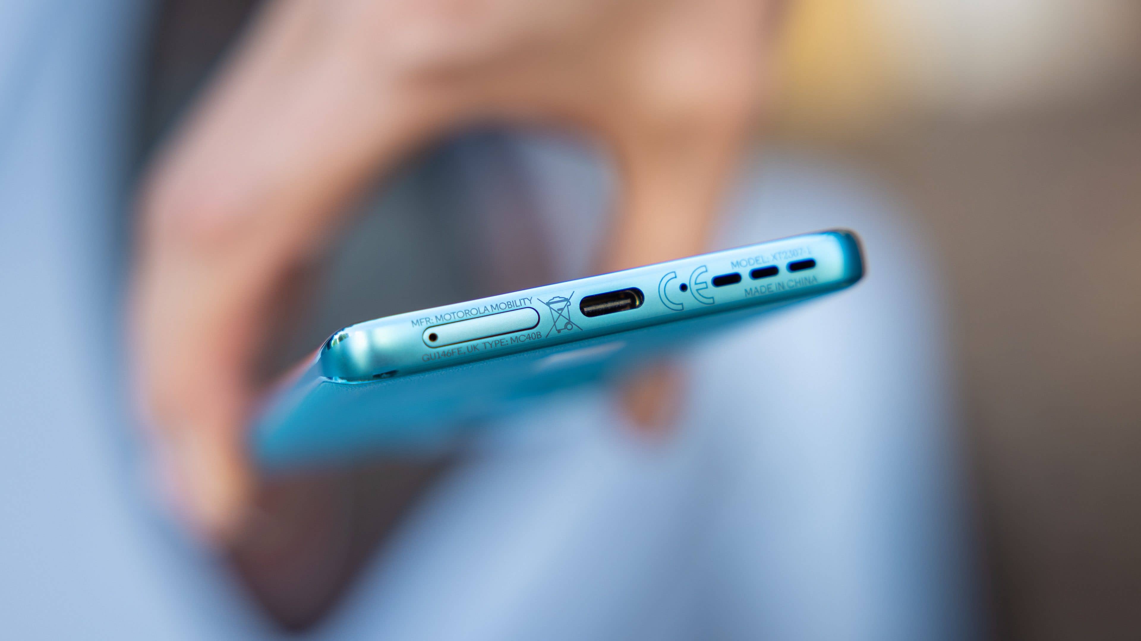 Le Motorola Edge 40 Neo tenu horizontalement avec vue sur son port USB-C sur la tranche transversale inférieure Le Motorola Edge 40 Neo tenu horizontalement avec vue sur son port USB-C sur la tranche transversale inférieure