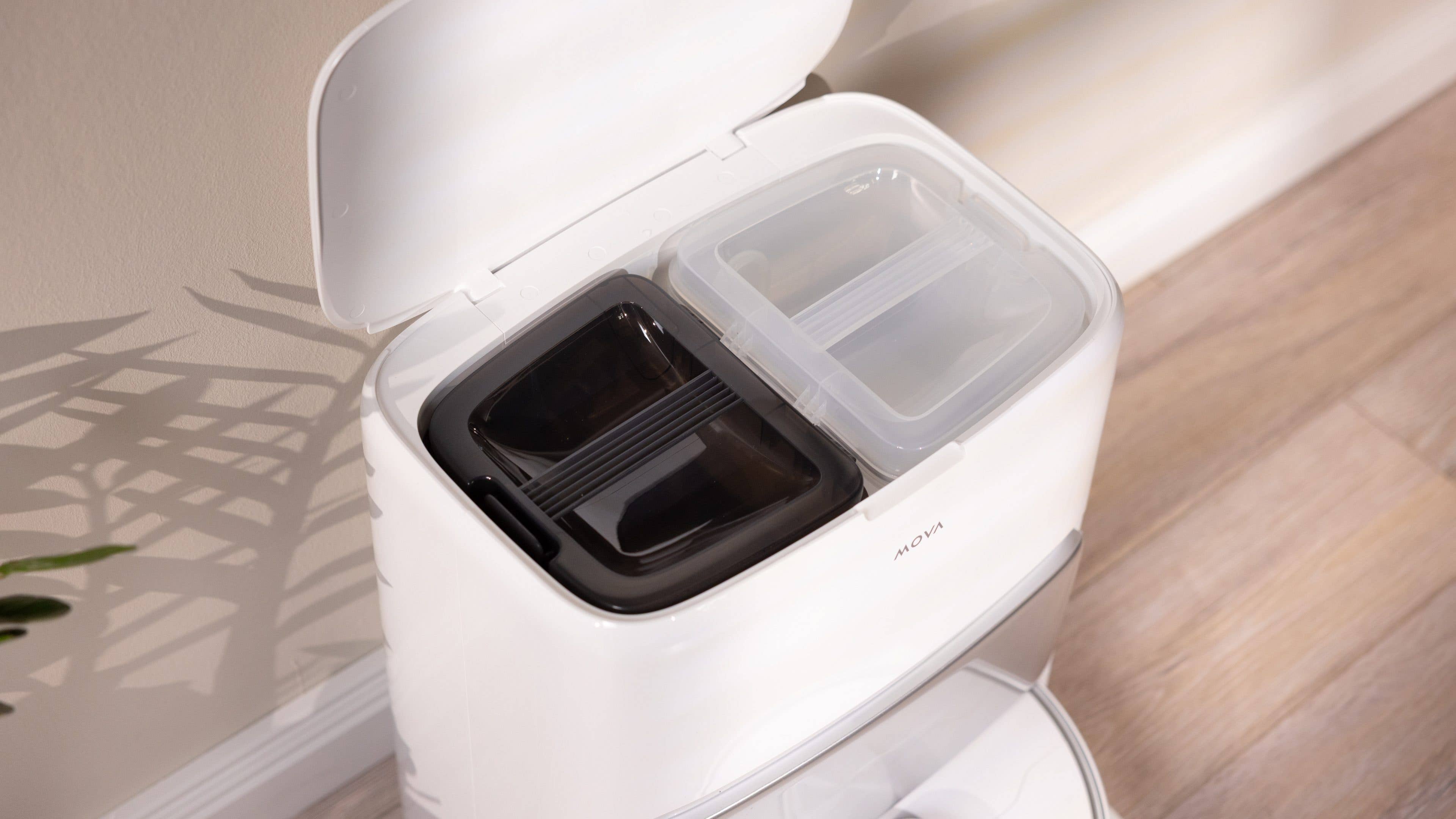 Un conteneur blanc avec deux compartiments, l'un sombre et l'autre clair, avec le couvercle ouvert.