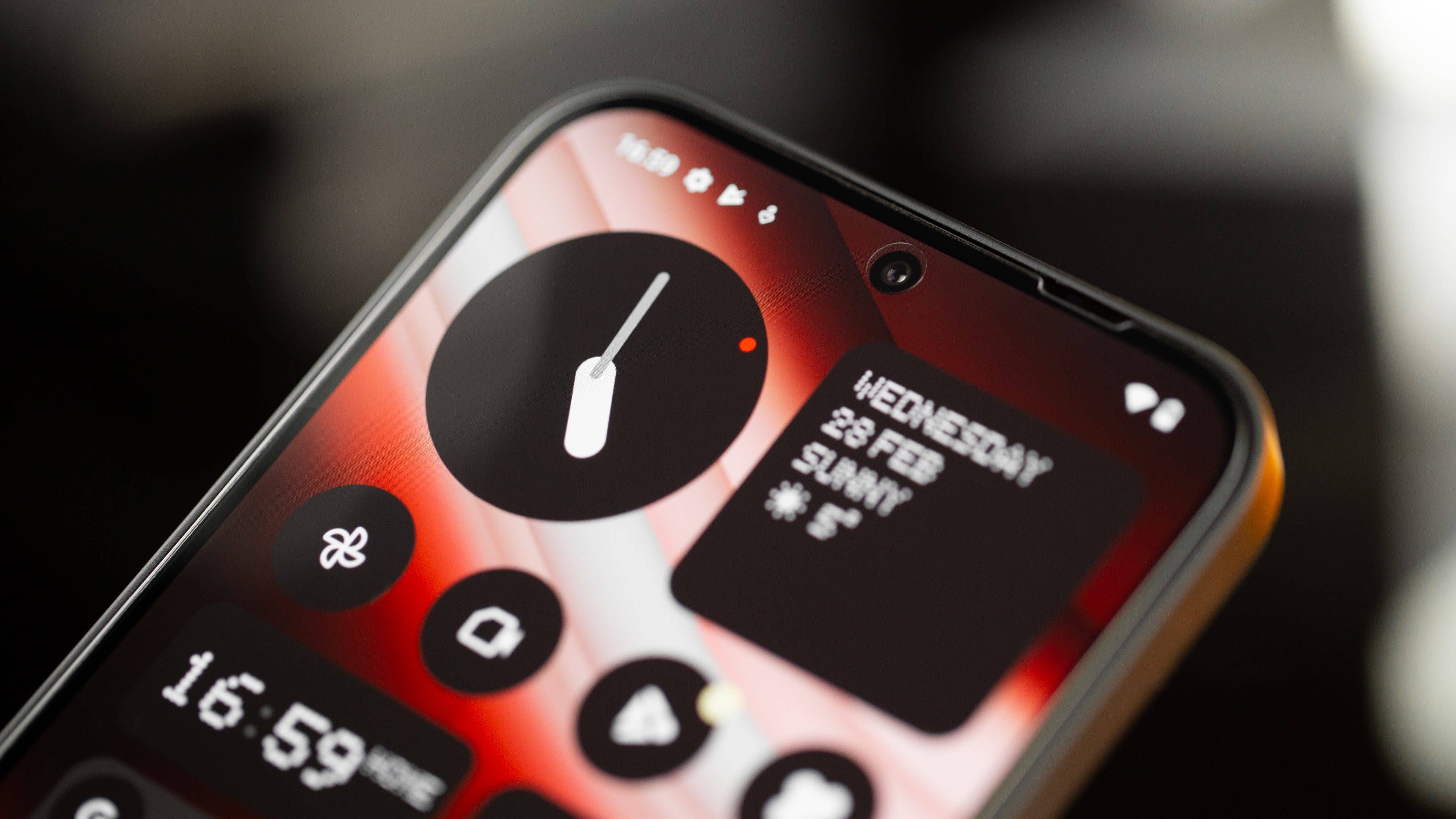 Le Nothing Phone (2a) vu de face avec un aperçu de la caméra selfie centrée en haut de son écran allumé
