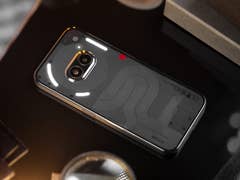 Le Nothing Phone (2a) posé face contre terre et vu de haut avec les LED de son interface Glyphe allumées