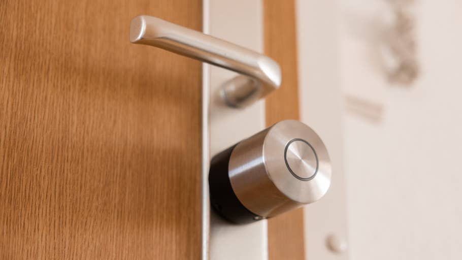 Gros plan du0027un Nuki Smart Lock Pro installé sur une porte en bois.
