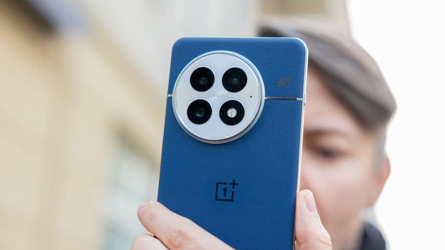 Une personne tenant le dos bleu du0027un smartphone OnePlus 13, mettant en valeur son design de caméra.