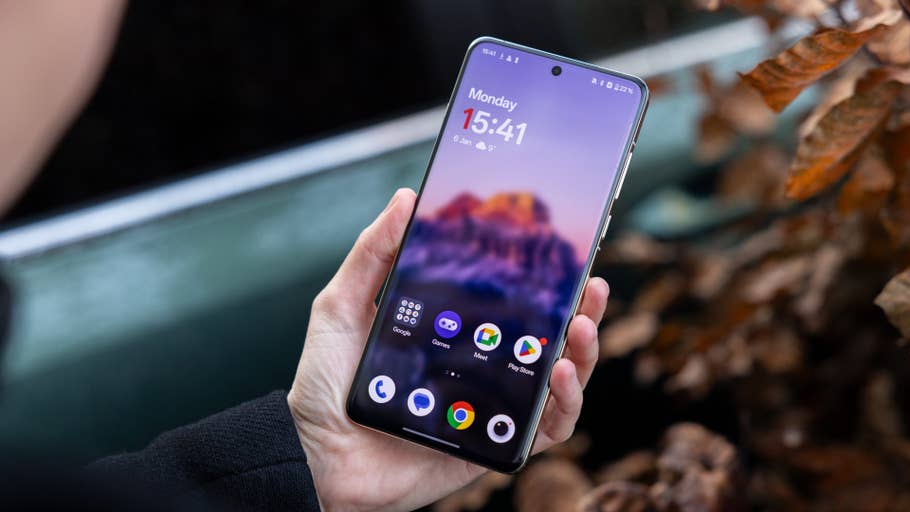 Une personne tenant un smartphone OnePlus 13 affichant lu0027écran du0027accueil avec lu0027heure et les applications.