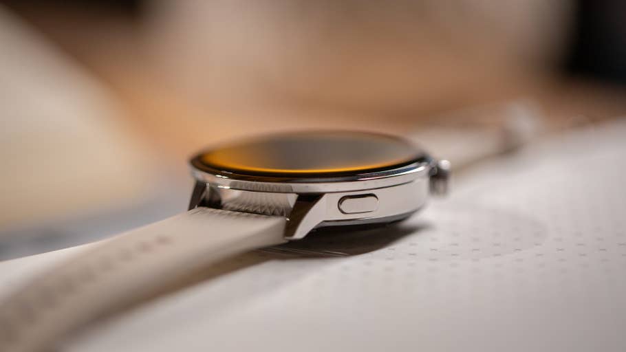 Vue rapprochée du0027une OnePlus Watch 3 avec un boîtier argenté et bracelet blanc sur une surface.