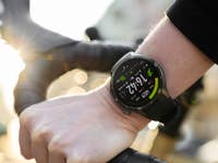 Gros plan d'un poignet avec une montre OnePlus tenant un guidon de vélo, affichant l'heure et des métriques.