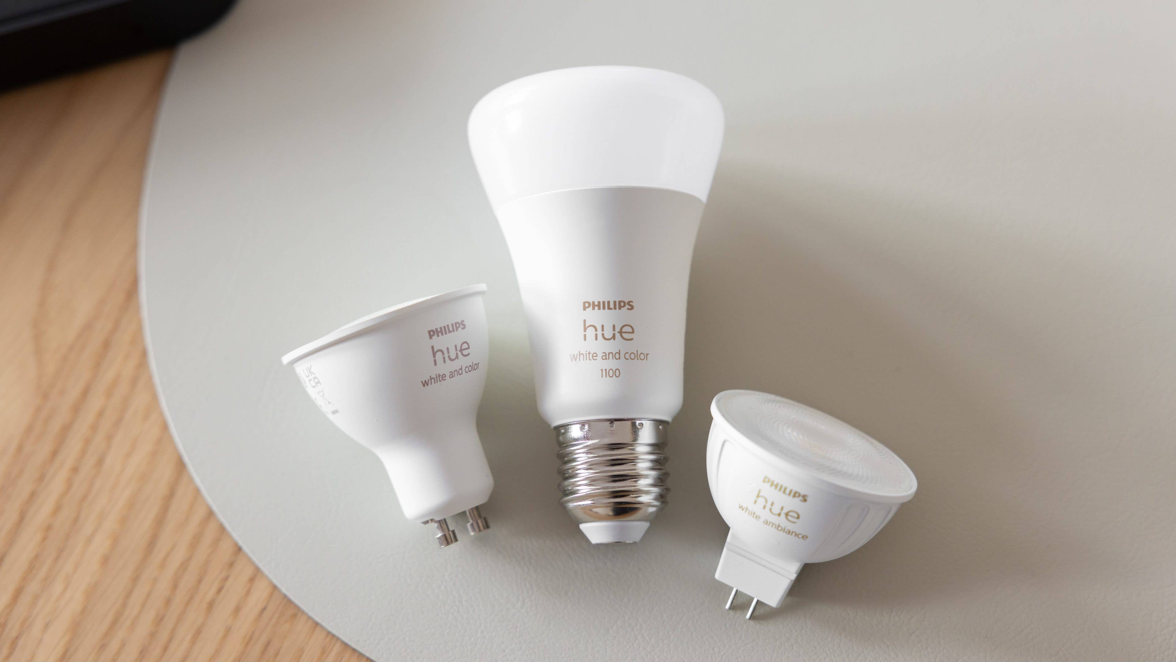 Trois ampoules intelligentes Philips Hue sur une surface claire. Trois ampoules intelligentes Philips Hue sur une surface claire.