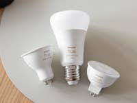 Trois ampoules intelligentes Philips Hue sur une surface claire.