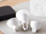 Une collection d'ampoules intelligentes Philips Hue et d'accessoires sur une surface en bois.