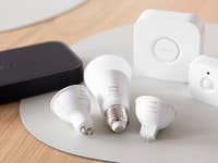 Une collection d'ampoules intelligentes Philips Hue et d'accessoires sur une surface en bois.