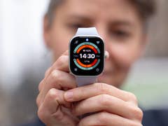 Une personne tient une montre Redmi 5 affichant l'heure et des données de santé.