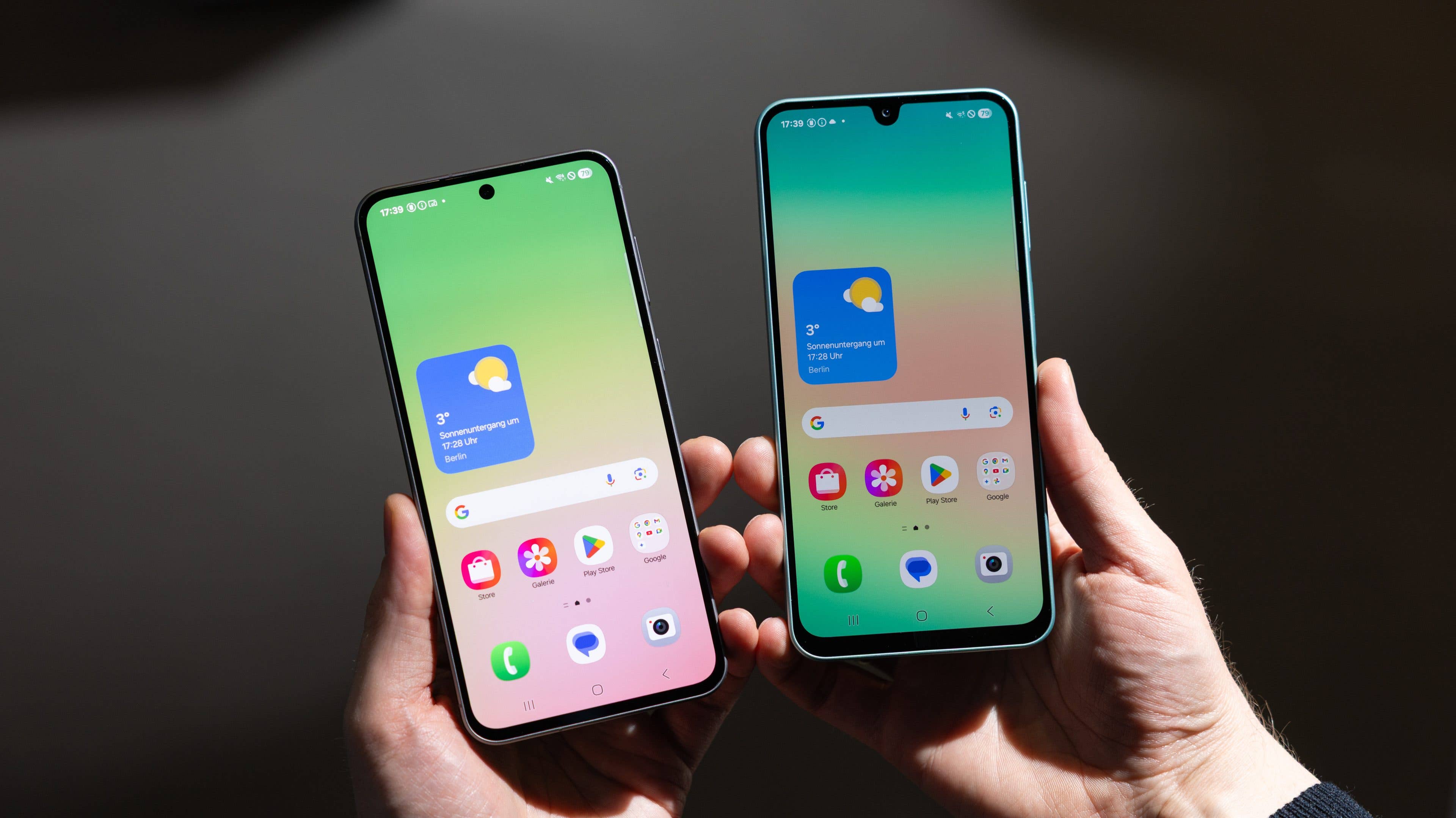 Deux smartphones Samsung Galaxy A series tenus en main, affichant des écrans colorés avec des informations météorologiques.