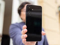 Une personne tenant un smartphone Samsung Galaxy A26, montrant son dos noir élégant.