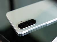 Un smartphone Samsung Galaxy A56 posé sur une surface en verre montre son module photo et son design.