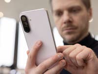 Une personne tenant un smartphone Samsung Galaxy A56, concentrée sur l'appareil.