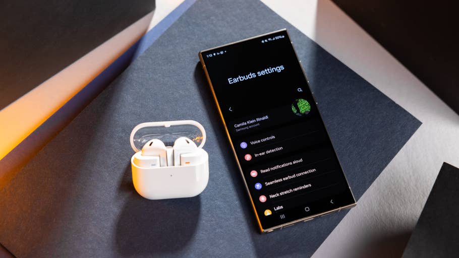 Boîtier de chargement Samsung Galaxy Buds 3 à côté du0027un smartphone affichant les paramètres des écouteurs.