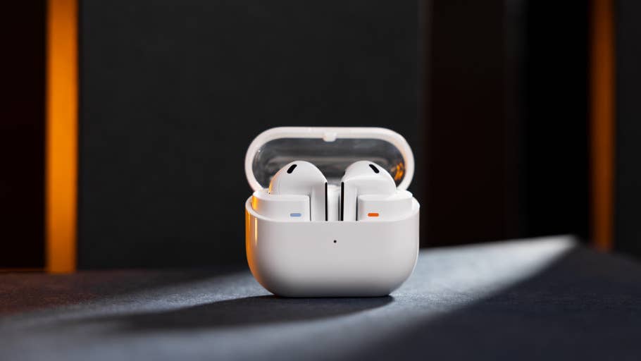 Samsung Galaxy Buds 3 dans un étui de chargement sur une surface sombre.
