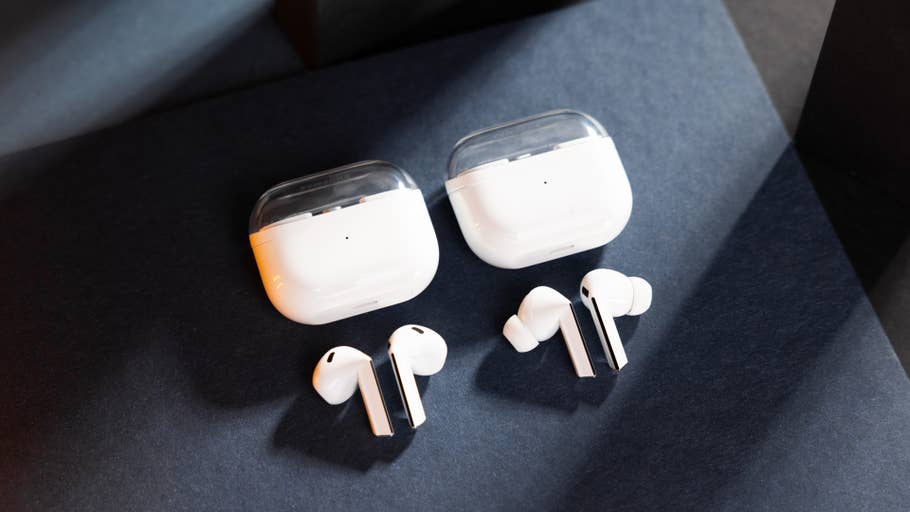 Deux paires du0027écouteurs sans fil Samsung Galaxy Buds 3 avec leurs étuis de chargement sur une surface sombre.