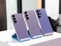 Trois smartphones Samsung Galaxy S25 exposés sur un support, mettant en avant leur design violet élégant.