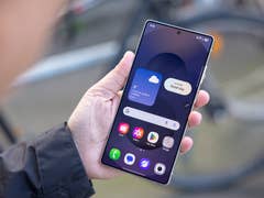 Une personne tenant un smartphone Samsung Galaxy S25 Ultra affichant des informations météorologiques et des icônes d'applications.