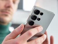 Une personne tenant un smartphone Samsung Galaxy S25, montrant les multiples objectifs de l'appareil photo.