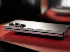 Le Samsung Galaxy Z Fold 6 plié et vu de côté, posé sur une feuille canson rouge.