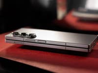 Le Samsung Galaxy Z Fold 6 plié et vu de côté, posé sur une feuille canson rouge.